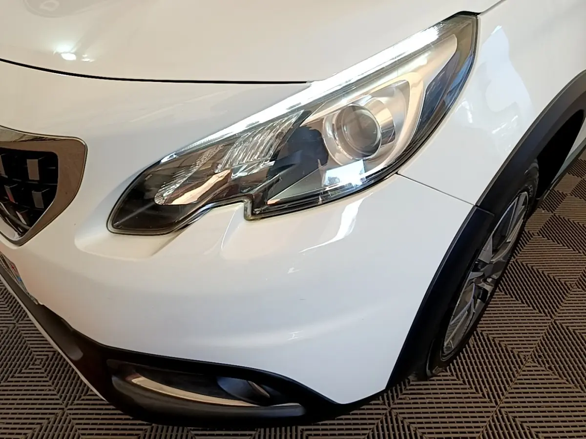 Gros plan sur l'avant droit blanc du Peugeot 2008, mettant en valeur le phare LED et la calandre chromée.