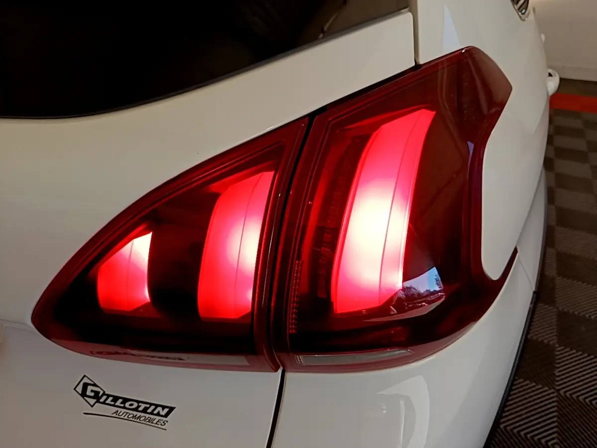 Gros plan sur le feu arrière droit rouge d’une Peugeot 2008 blanche, avec partie de la carrosserie visible.