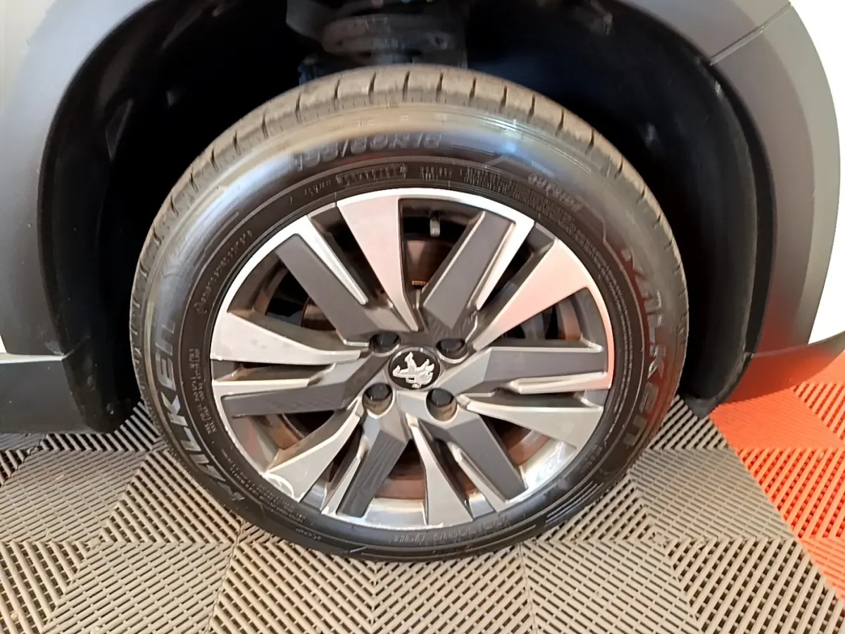Gros plan sur la roue avant droite du Peugeot 2008 2019, jante alliage bicolore avec logo lion au centre.