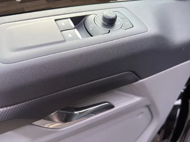 Gros plan sur la commande des vitres et rétroviseurs côté conducteur du Ford Transit Fourgon noir, intérieur gris.