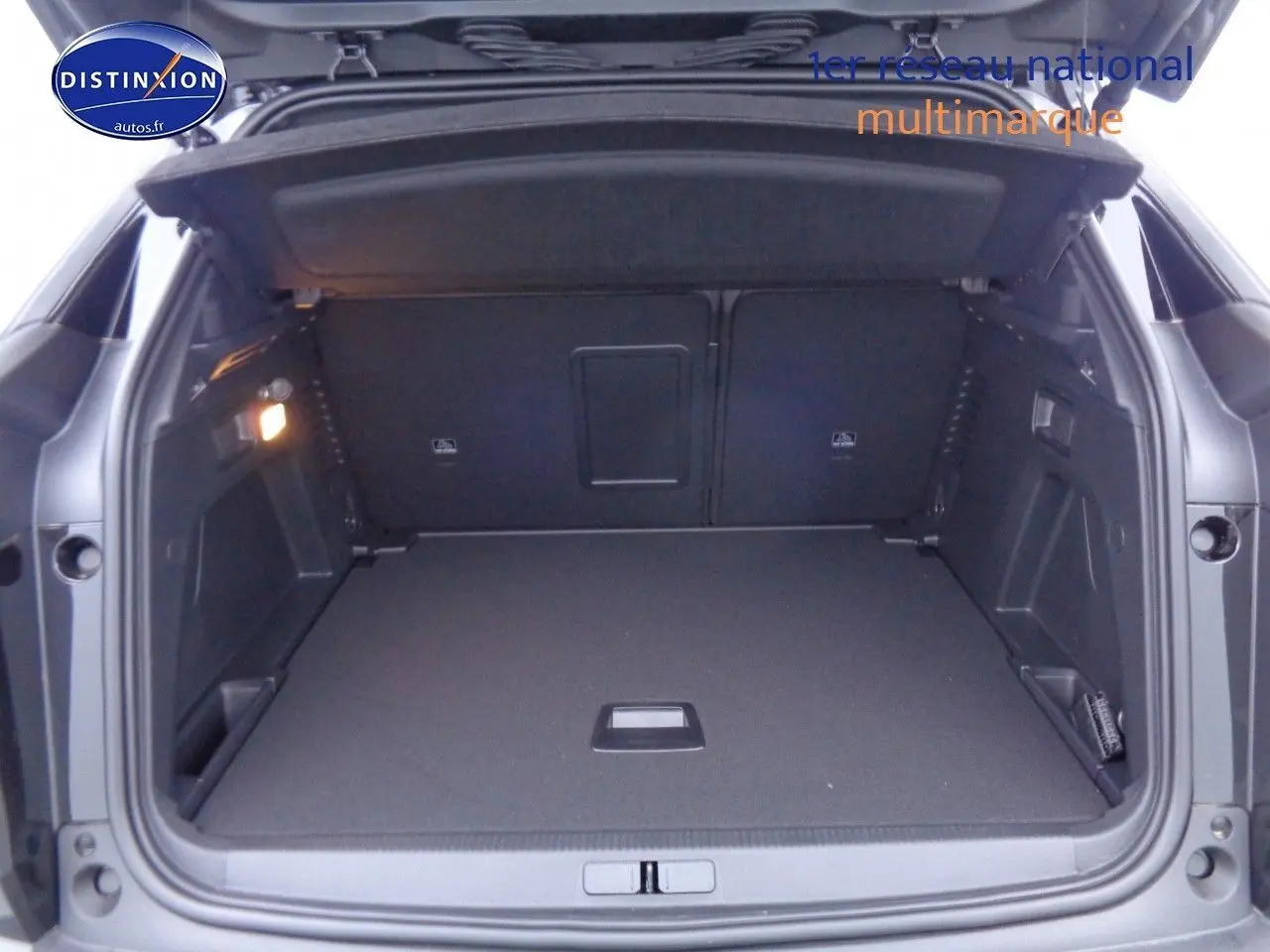 Coffre ouvert du Peugeot 3008 noir perla metal, vue arrière montrant un espace de chargement spacieux et bien éclairé.