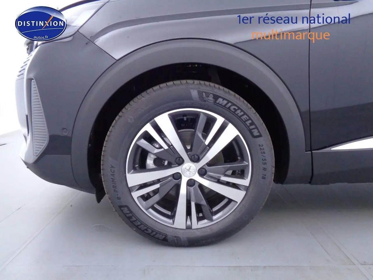 Gros plan sur la roue avant gauche du Peugeot 3008 noir Perla Metal avec jante alliage bicolore et pneu Michelin.