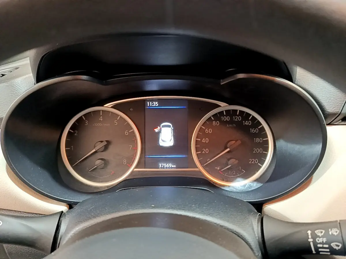 Vue rapprochée du tableau de bord de la Nissan Micra blanche, affichant compte-tours, vitesse et écran central numérique.