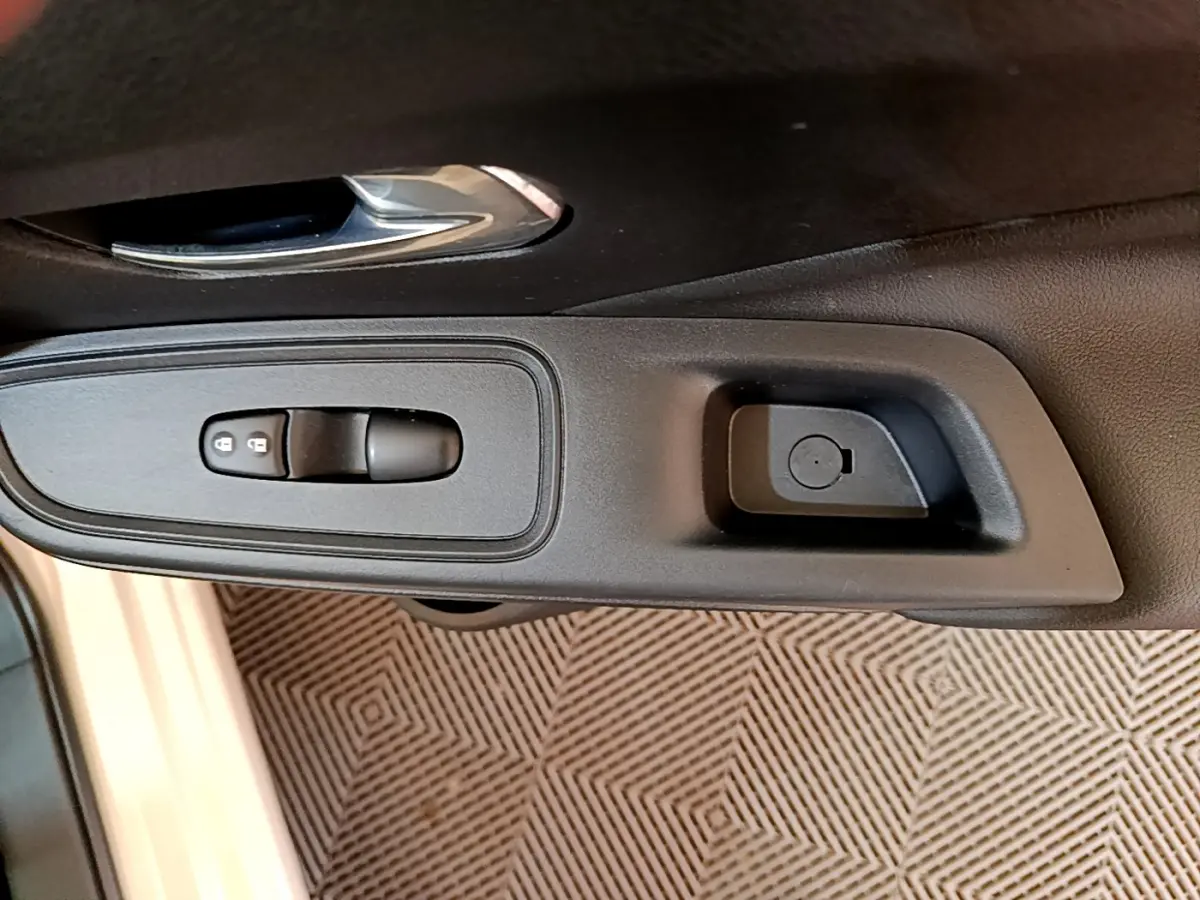 Gros plan sur la commande de verrouillage des portes côté conducteur d'une Nissan Micra blanche 2022.