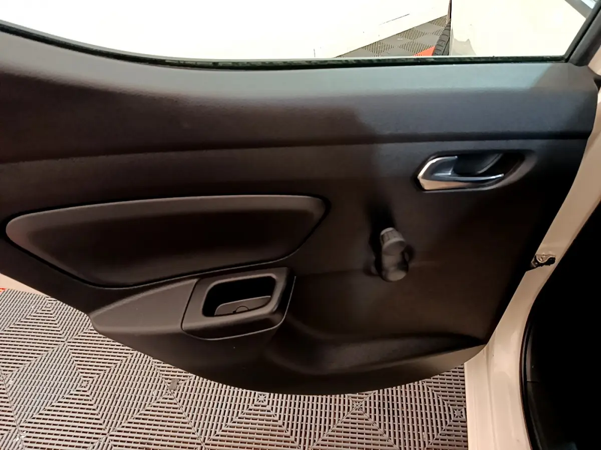 Vue rapprochée de la porte côté droit de la Nissan Micra blanche 2022 avec poignée et manivelle de vitre manuelle.