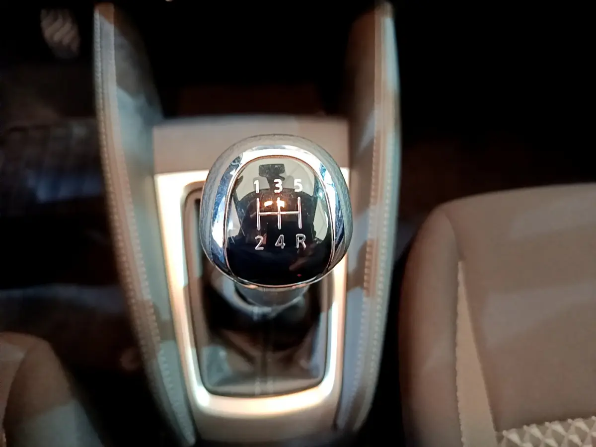 Gros plan sur le levier de vitesses manuel noir et chrome de la Nissan Micra IG-T 92 Acenta 2022, intérieur beige.