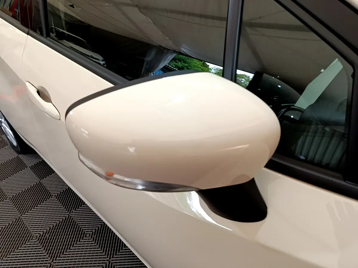 Gros plan sur le rétroviseur côté gauche blanc d'une Nissan Micra IG-T 92 Acenta 2022 essence.