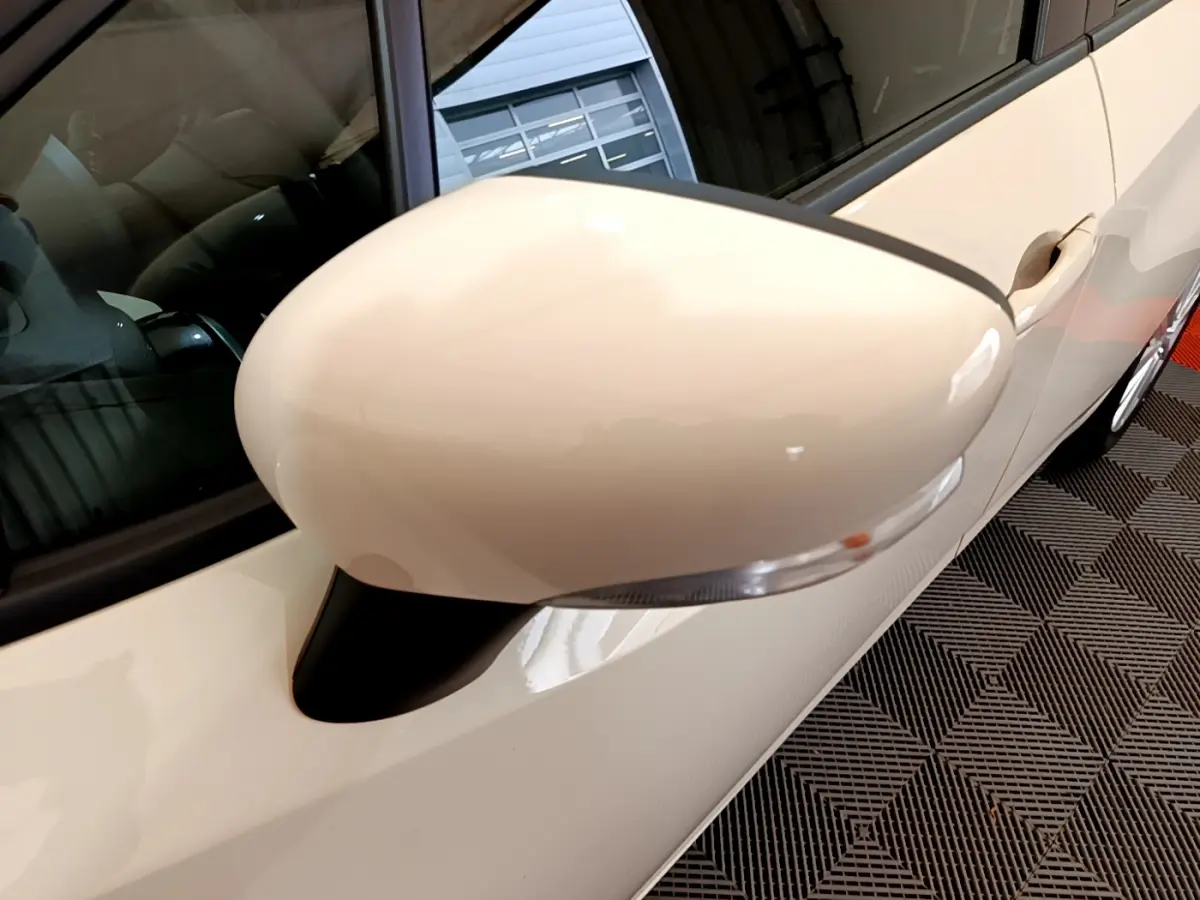 Rétroviseur côté gauche blanc de la Nissan Micra IG-T 92 Acenta 2022, vue rapprochée sur la portière et vitre.