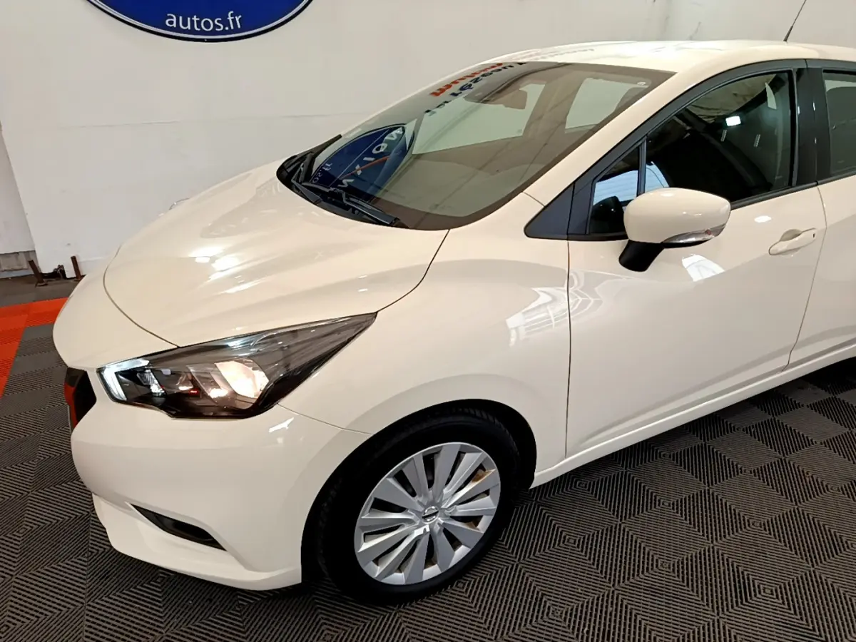 Nissan Micra IG-T 92 Acenta blanche vue 3/4 avant droit avec phares allumés et jantes alliage visibles