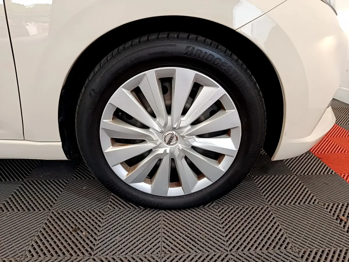 Gros plan sur la roue avant gauche blanche d'une Nissan Micra IG-T 92 Acenta 2022 avec enjoliveur argenté.