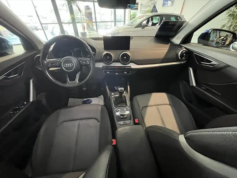 Intérieur de l'Audi Q2 30 TFSI S-Line 2021, vue frontale du poste de conduite avec volant multifonction et boîte manuelle.