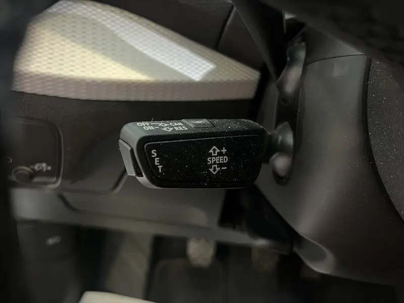 Gros plan sur la commande de régulateur de vitesse à gauche du volant dans l'Audi Q2 Bleu Navarre 2021 finition S-Line.