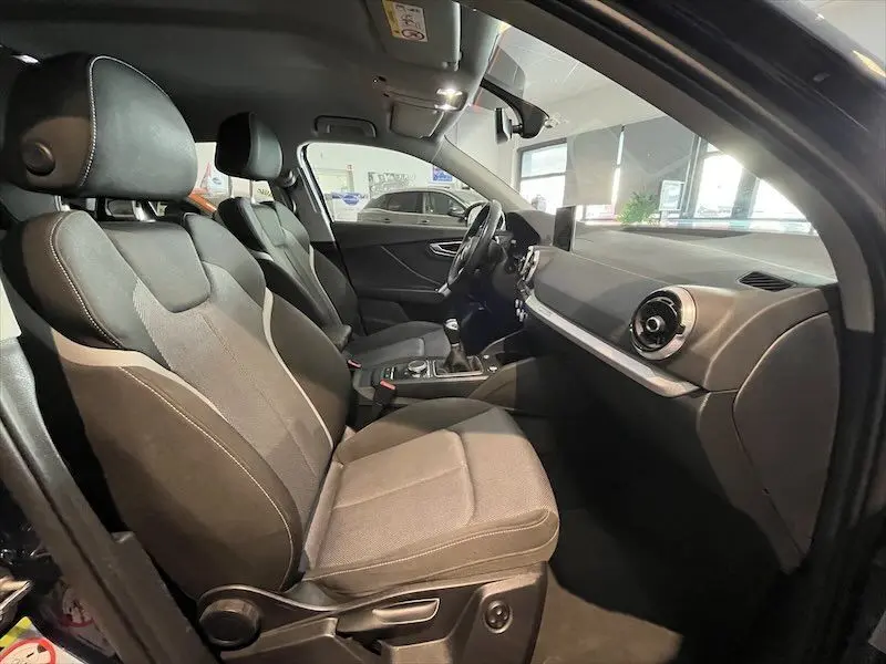 Intérieur de l'Audi Q2 30 TFSI S-Line 2021 vu côté droit, sièges tissu gris et tableau de bord moderne.