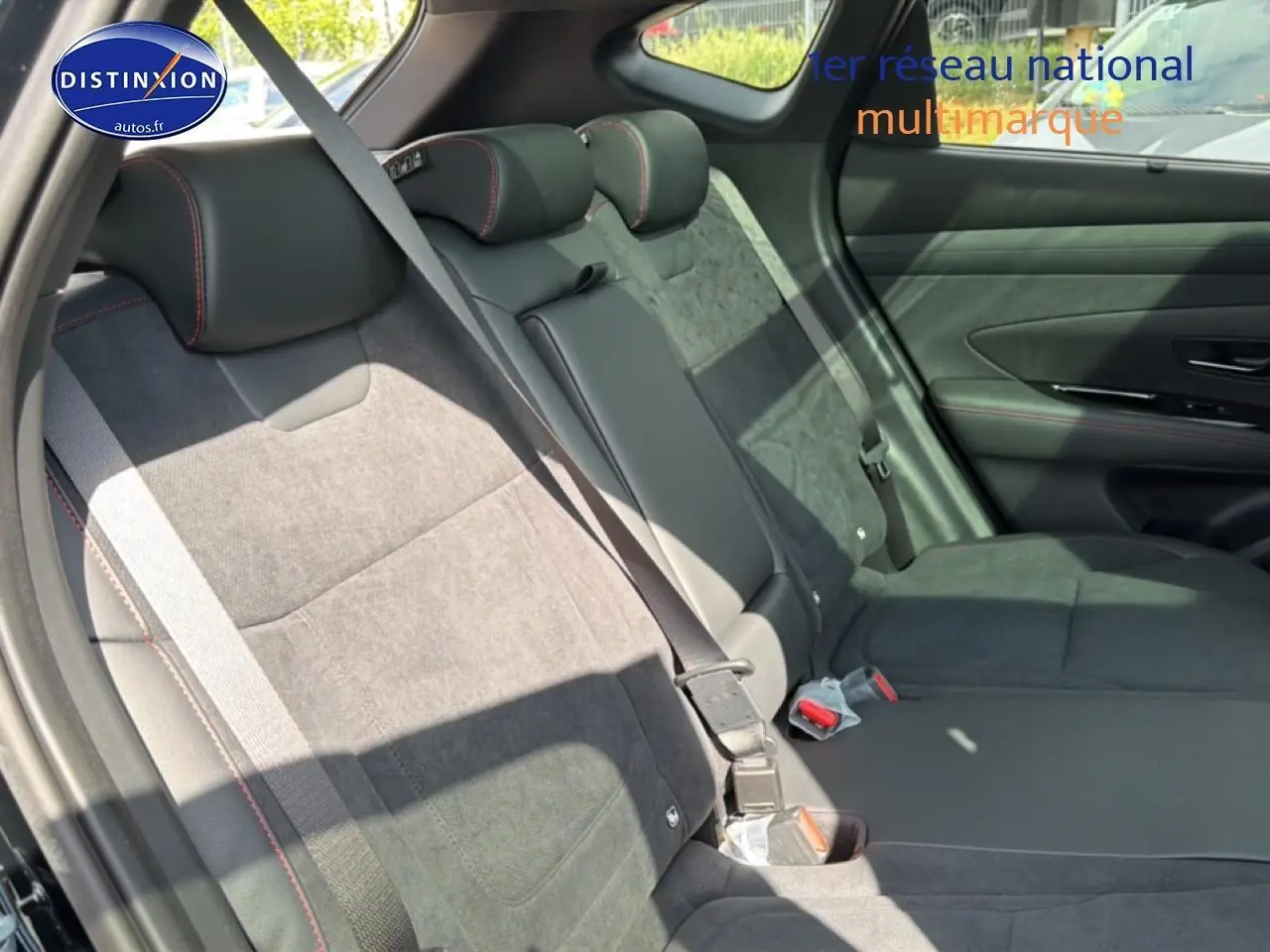 Vue latérale droite des sièges arrière noirs en cuir et alcantara avec surpiqûres rouges du Hyundai Tucson 2026 hybride N Line Executive.