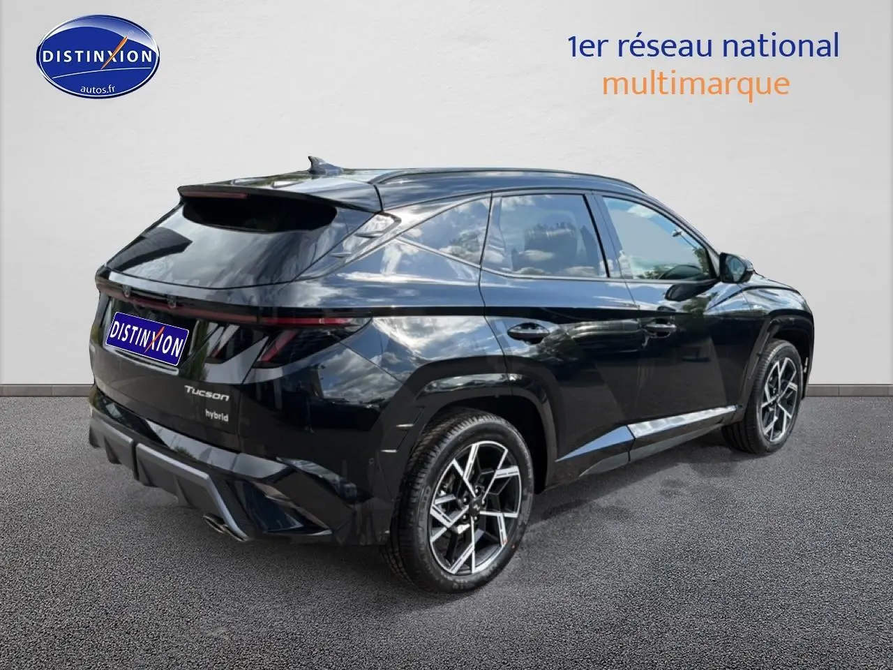 Vue 3/4 arrière droite du Hyundai Tucson noir hybride avec jantes alu et feux arrière LED étirés.