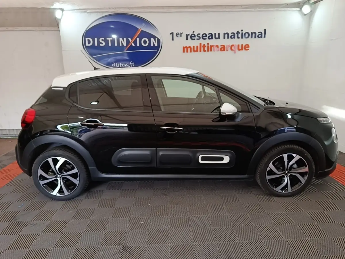 Citroën C3 noire vue de profil côté gauche, toit blanc et inserts décoratifs sur les portes.