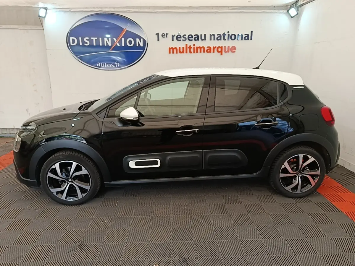 Profil gauche d'une Citroën C3 noire 2022 avec toit blanc et protections latérales distinctives.