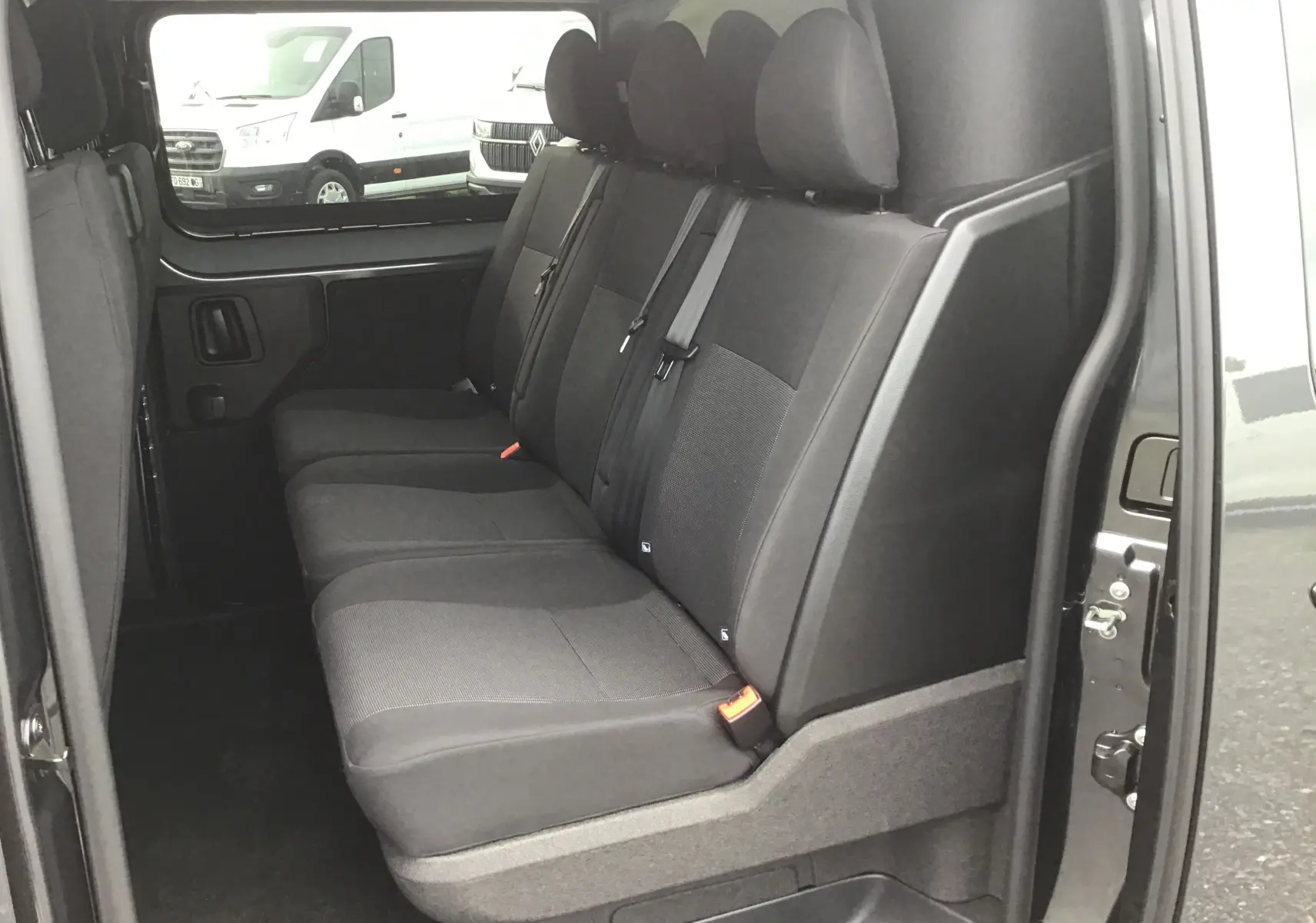 Vue latérale droite sur les sièges arrière noirs du Citroën Jumpy Cabine Approfondie gris titane, version 6 places.
