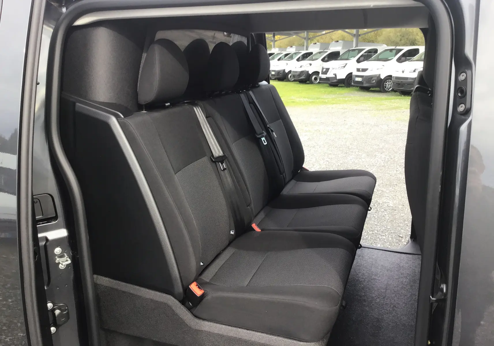 Banquette arrière noire vue de côté gauche dans un Citroën Jumpy Cabine Approfondie gris titane avec portes ouvertes.