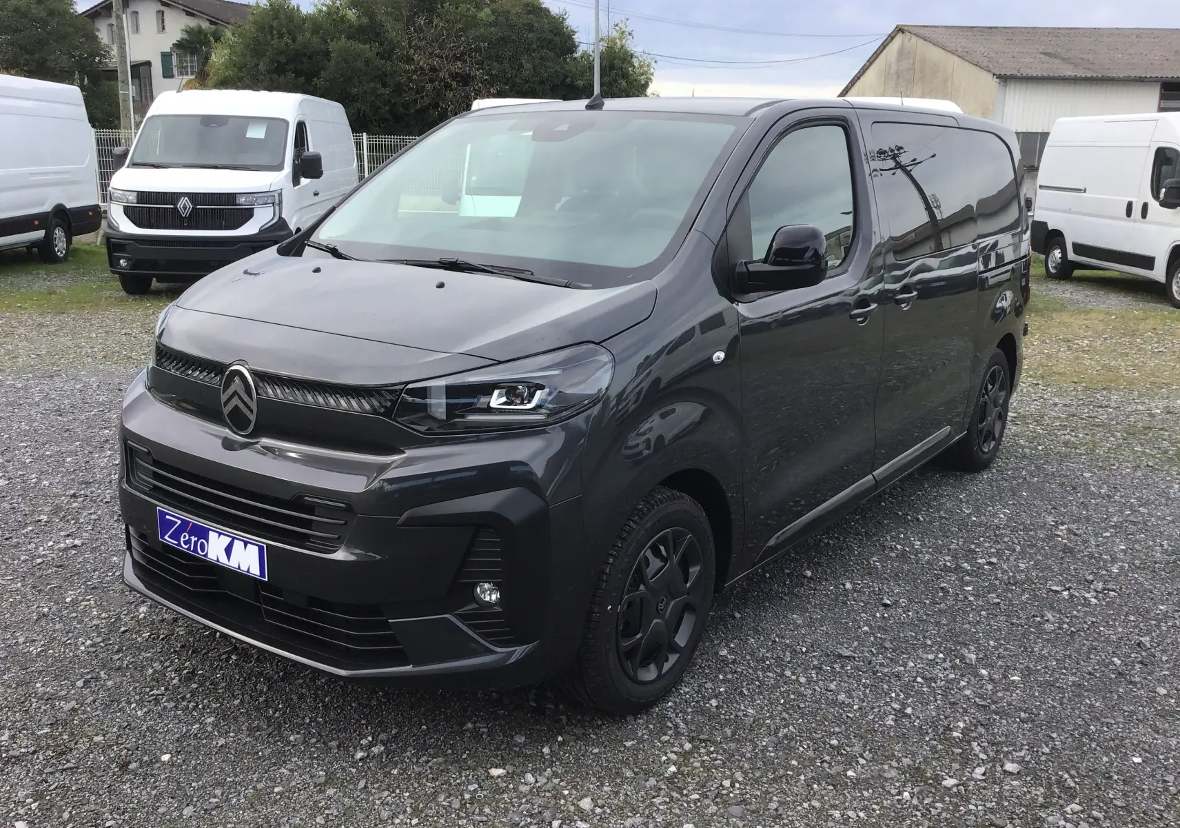 Citroën Jumpy cabine approfondie gris titane en 3/4 avant droit avec calandre noire et jantes foncées sur parking.