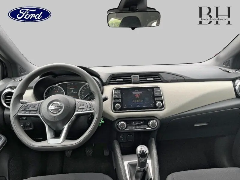 Vue intérieure du tableau de bord de la Nissan Micra 2022 avec volant multifonction et écran tactile central beige et noir