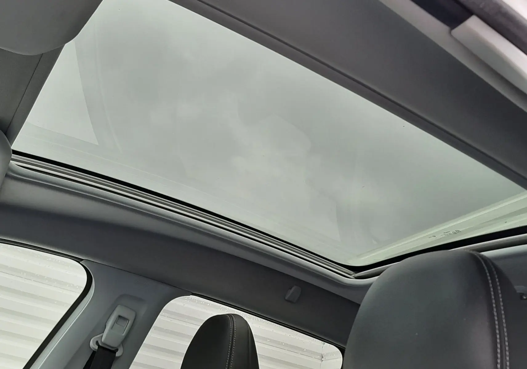 Toit panoramique en verre et sièges avant en cuir noir à l'intérieur d'un Peugeot 2008 blanc de 2017.