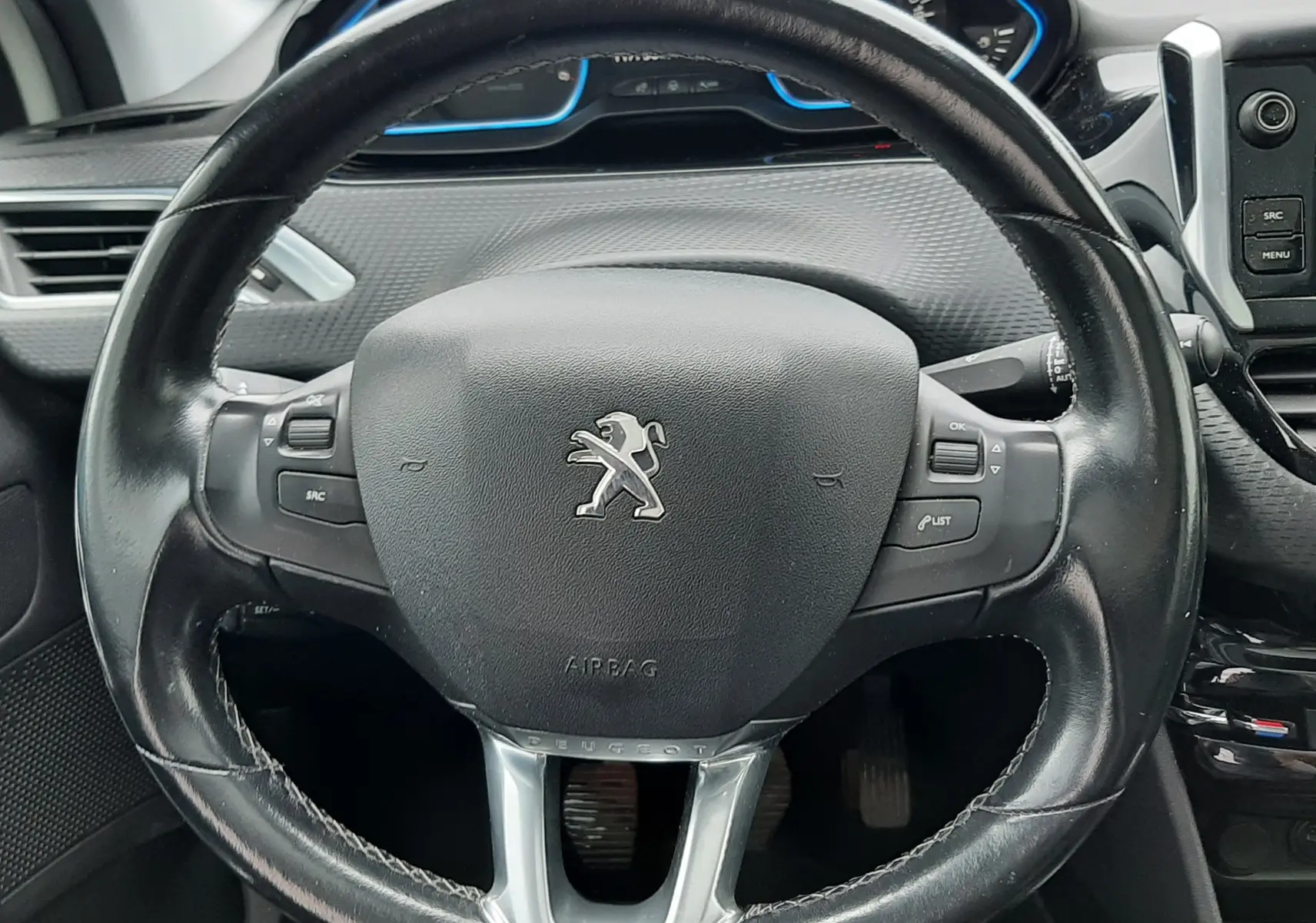 Volant en cuir noir de Peugeot 2008 2017 avec commandes intégrées et tableau de bord partiellement visible.