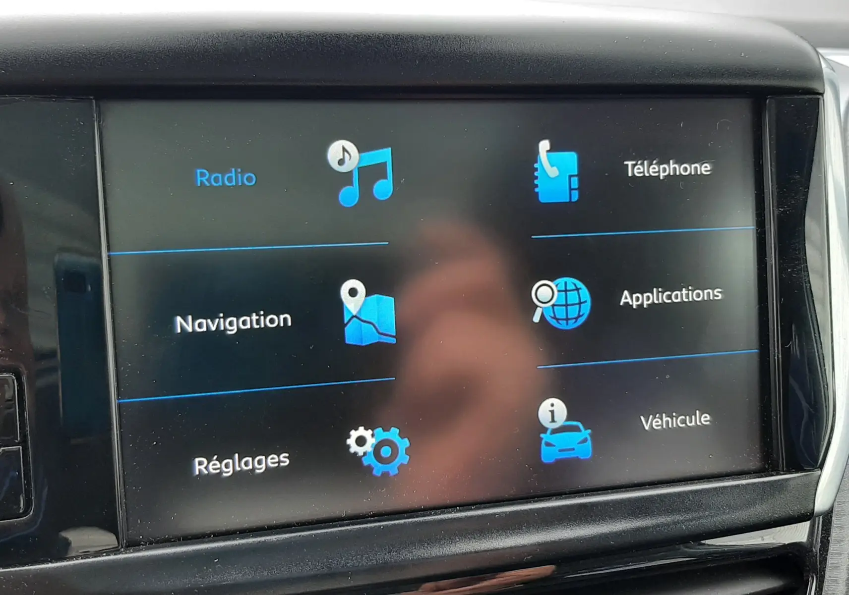 Écran tactile central du tableau de bord du Peugeot 2008 2017 affichant les menus radio, téléphone, navigation, applications, réglages et véhicule.