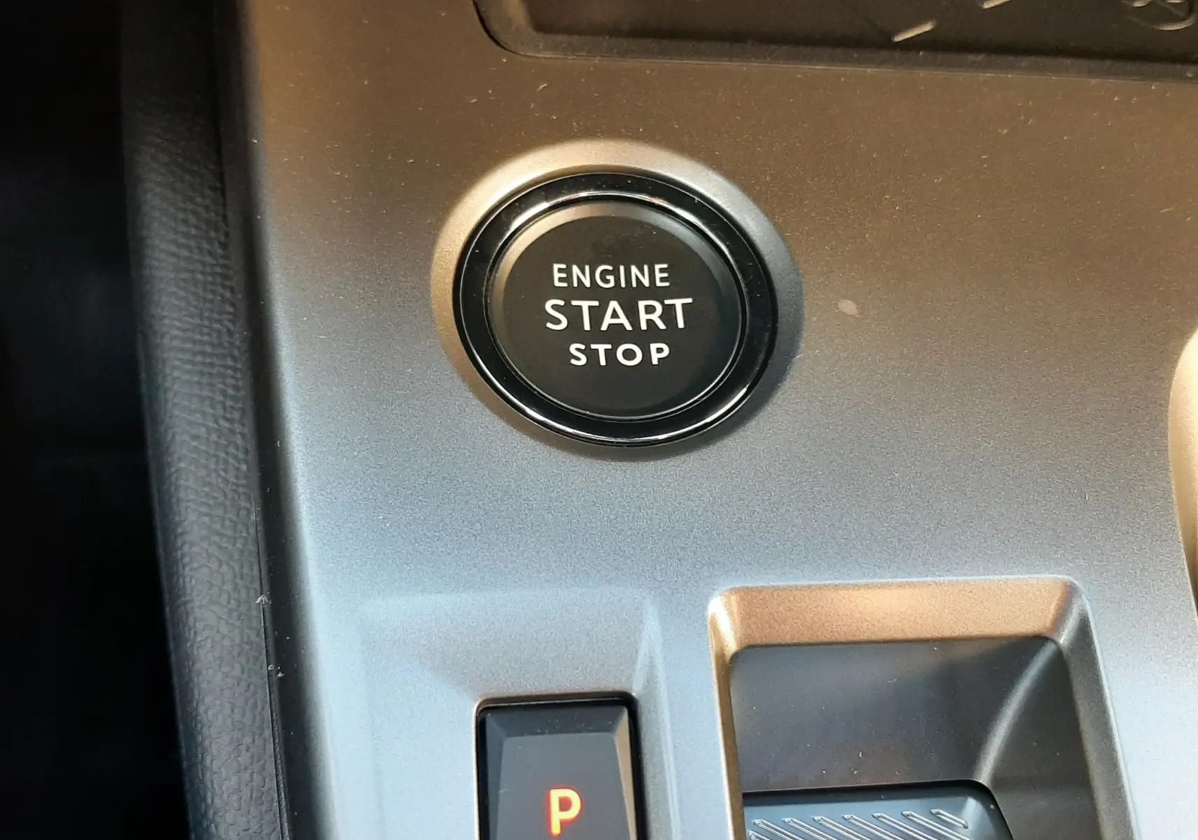 Gros plan sur le bouton start/stop et la commande de boîte automatique dans l'habitacle gris d'une Peugeot 308 2025.