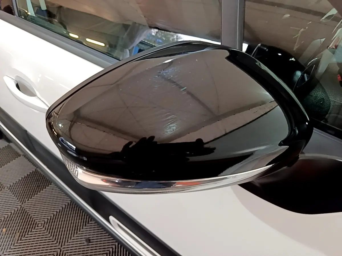 Rétroviseur noir brillant côté gauche d'une Citroën C3 blanche PureTech 83 Shine 2023, vue rapprochée.