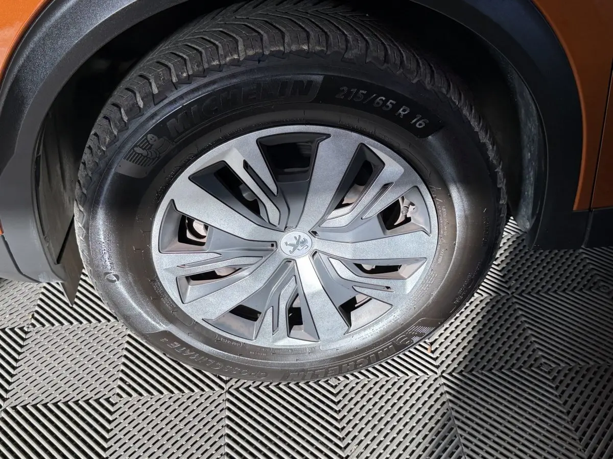 Gros plan sur la roue avant droite orange du Peugeot 2008 avec jante en alliage et pneu Michelin.