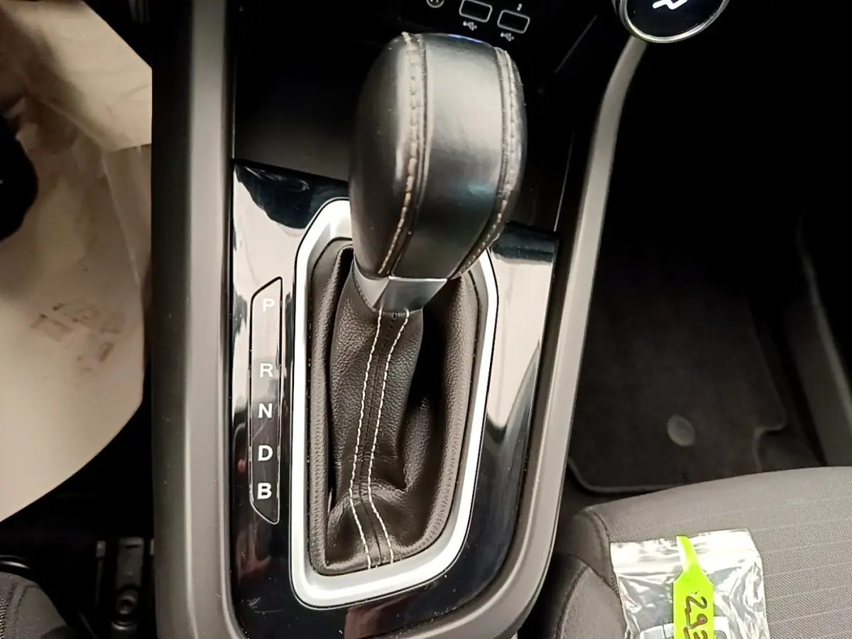 Le levier de vitesses automatique en cuir noir du Renault Arkana Evolution E-Tech, vue rapprochée de la console centrale.
