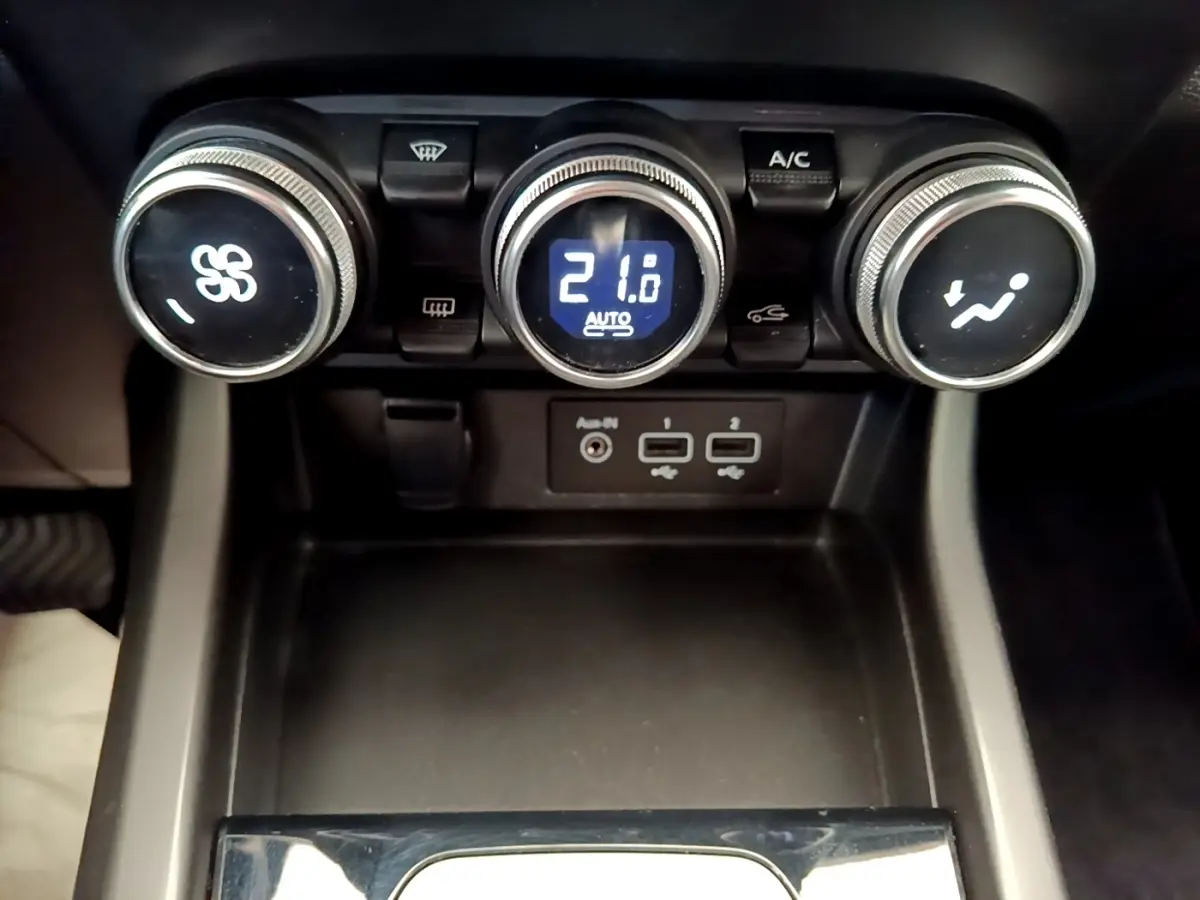 Vue rapprochée des commandes de climatisation et des ports USB du Renault Arkana gris clair Evolution E-Tech 2023.