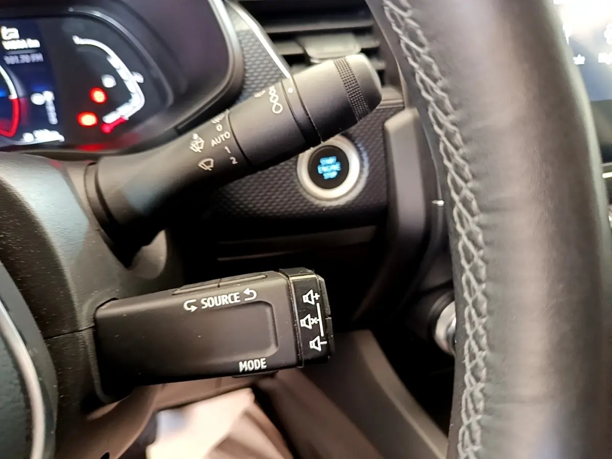 Gros plan sur la commande multifonctions côté gauche du volant en cuir noir du Renault Arkana gris clair.