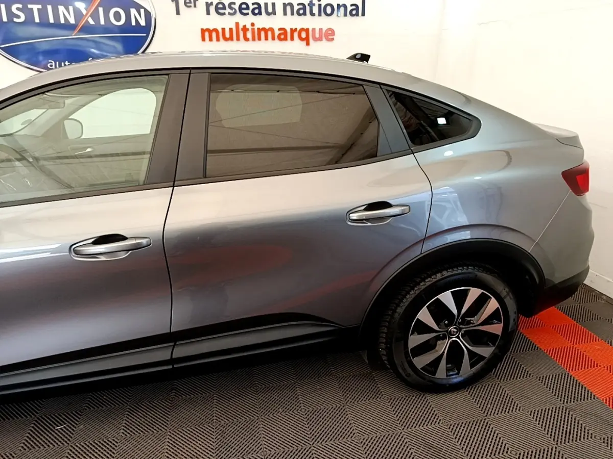 Vue latérale droite d'un Renault Arkana gris clair 2023 avec jantes alliage et vitres teintées.
