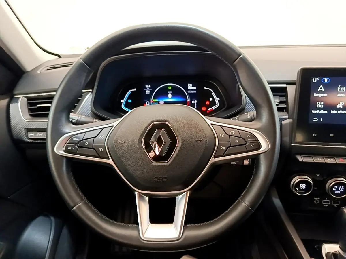 Vue rapprochée du volant en cuir noir du Renault Arkana 2023 avec tableau de bord numérique et écran tactile central.