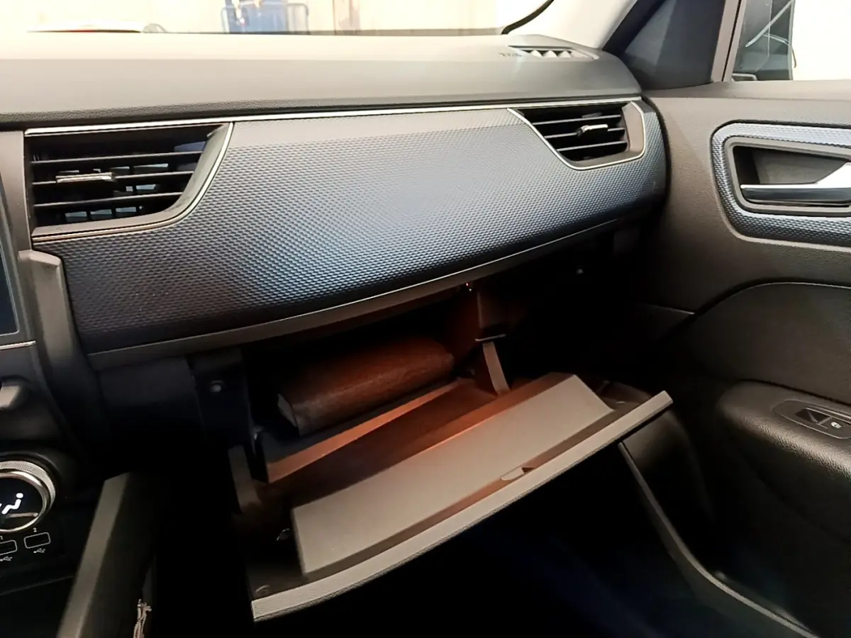 Vue intérieure côté passager du tableau de bord gris foncé avec boîte à gants ouverte du Renault Arkana Evolution E-Tech 2023.