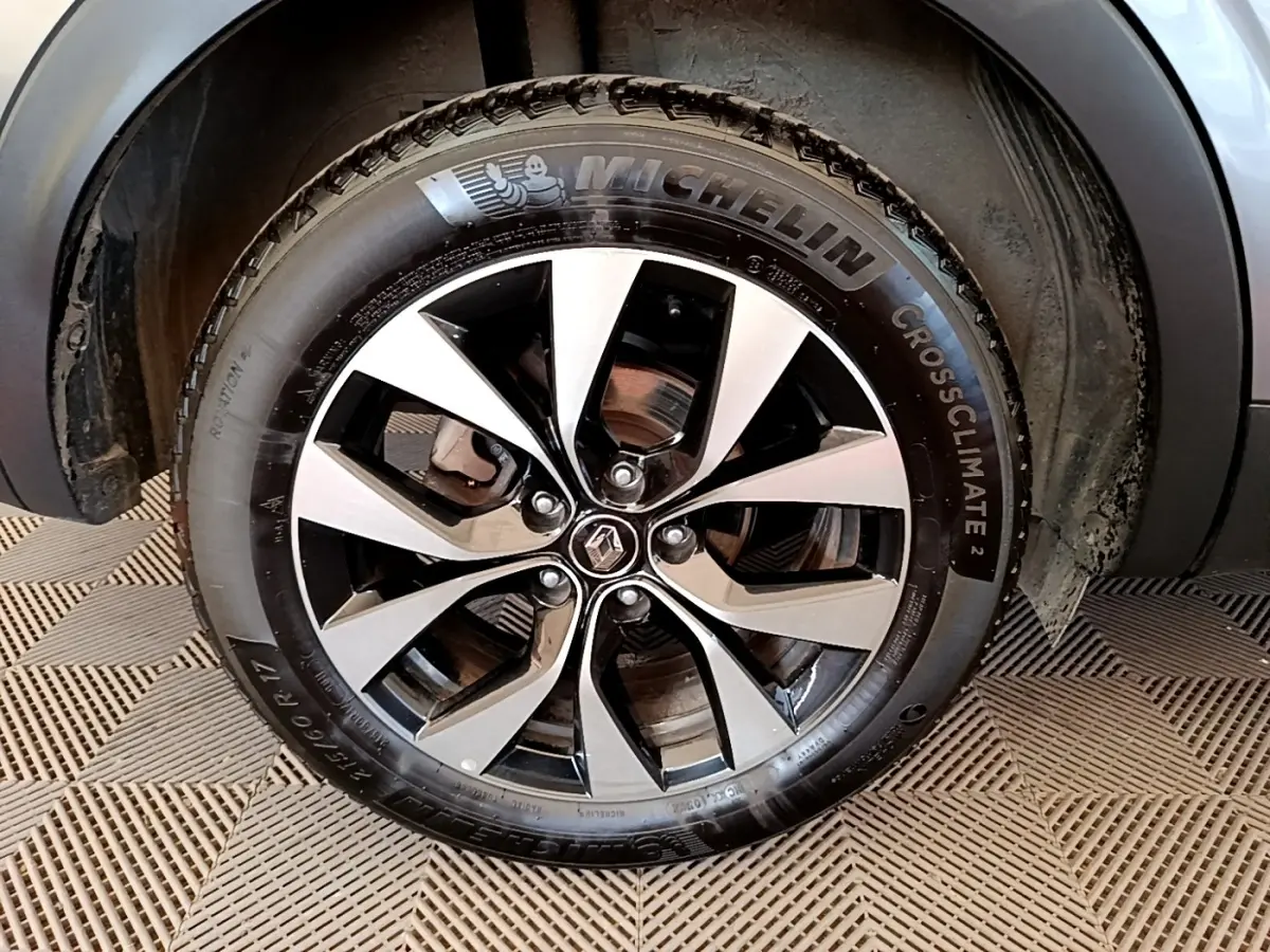 Gros plan sur la roue avant droite gris clair du Renault Arkana 2023 avec jante alliage et pneu Michelin CrossClimate.