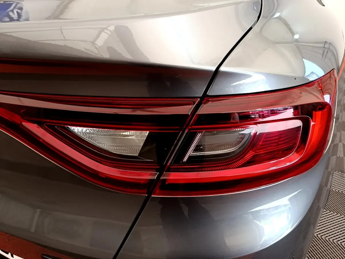 Gros plan sur le feu arrière droit rouge et blanc du Renault Arkana gris clair Evolution E-Tech 2023.