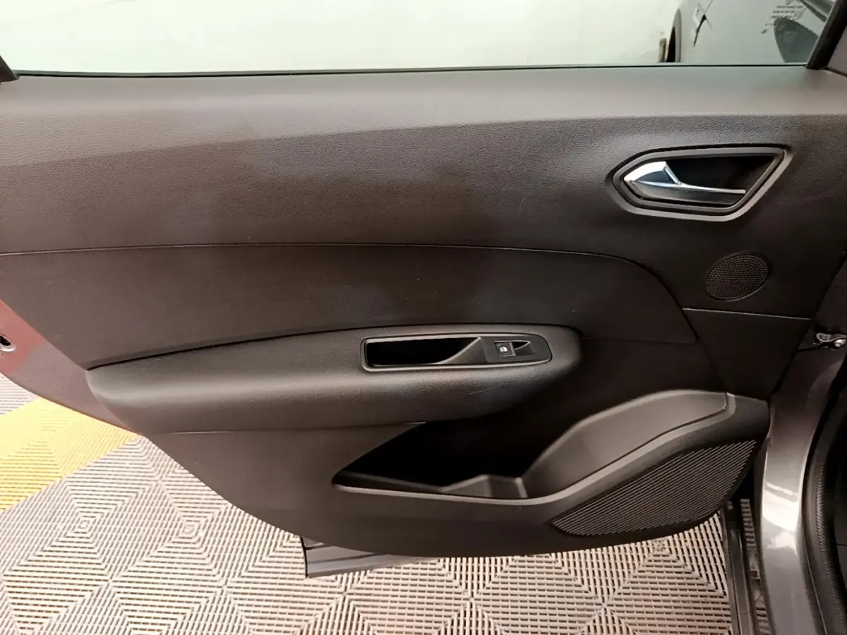 Vue intérieure côté gauche de la porte avant grise du Renault Arkana, avec poignée et commande de fenêtre noire.