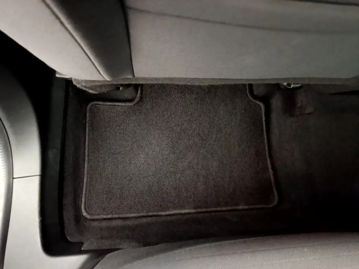 Vue rapprochée du tapis de sol noir côté passager arrière du Renault Arkana gris clair 2023.