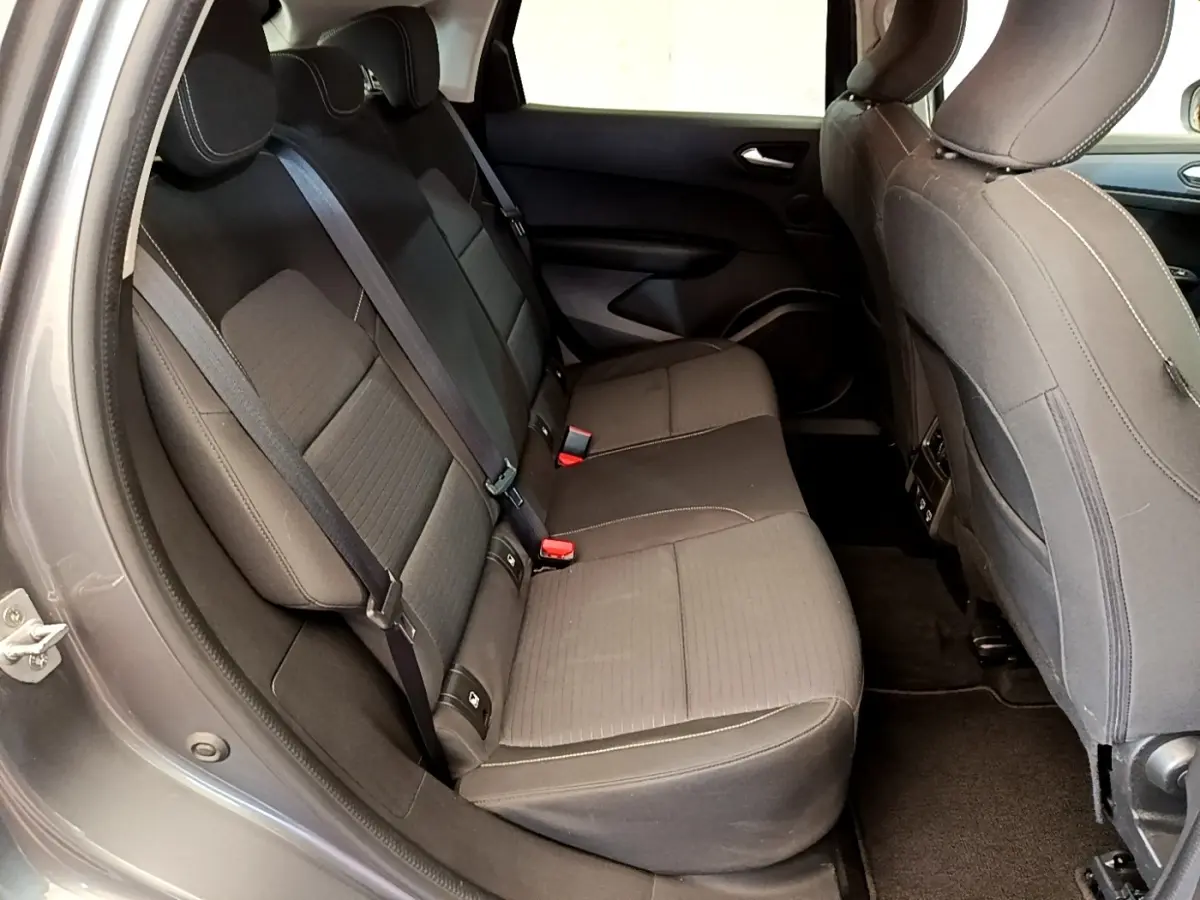 Vue intérieure côté gauche des sièges arrière gris foncé du Renault Arkana Evolution E-Tech 2023 avec ceintures de sécurité visibles.