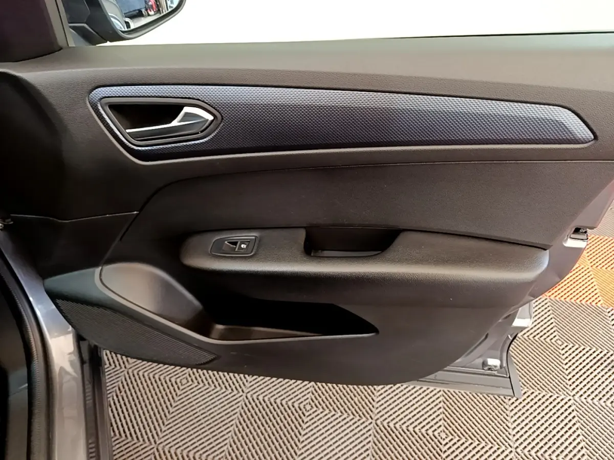 Vue rapprochée de la porte avant gauche gris clair du Renault Arkana Evolution E-Tech avec poignée et commande de vitre.