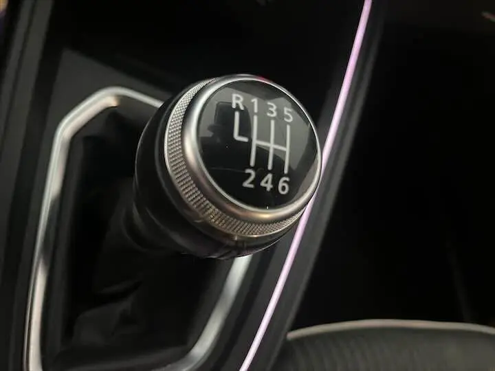 Gros plan sur le levier de vitesses manuel de la Renault Clio V blanc nacré, mettant en valeur la grille 6 rapports.