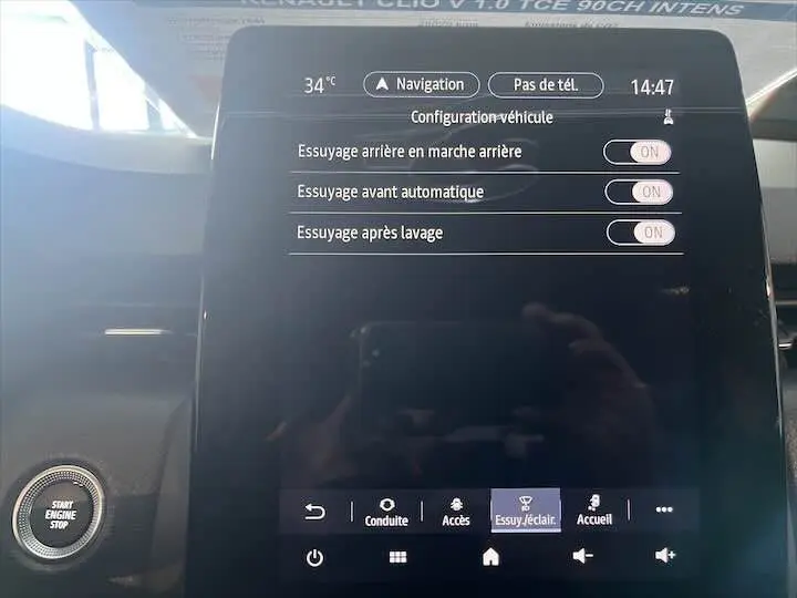 Écran tactile central de la Renault Clio V blanc nacré, affichant les réglages d'essuyage avec bouton start visible à gauche