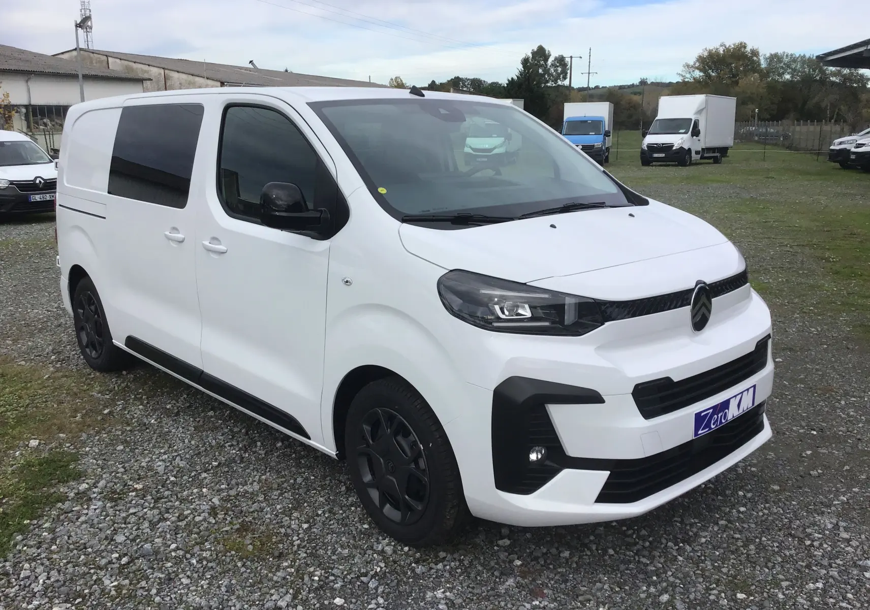Citroën Jumpy cabine approfondie blanc en 3/4 avant droit avec jantes noires et vitres teintées.