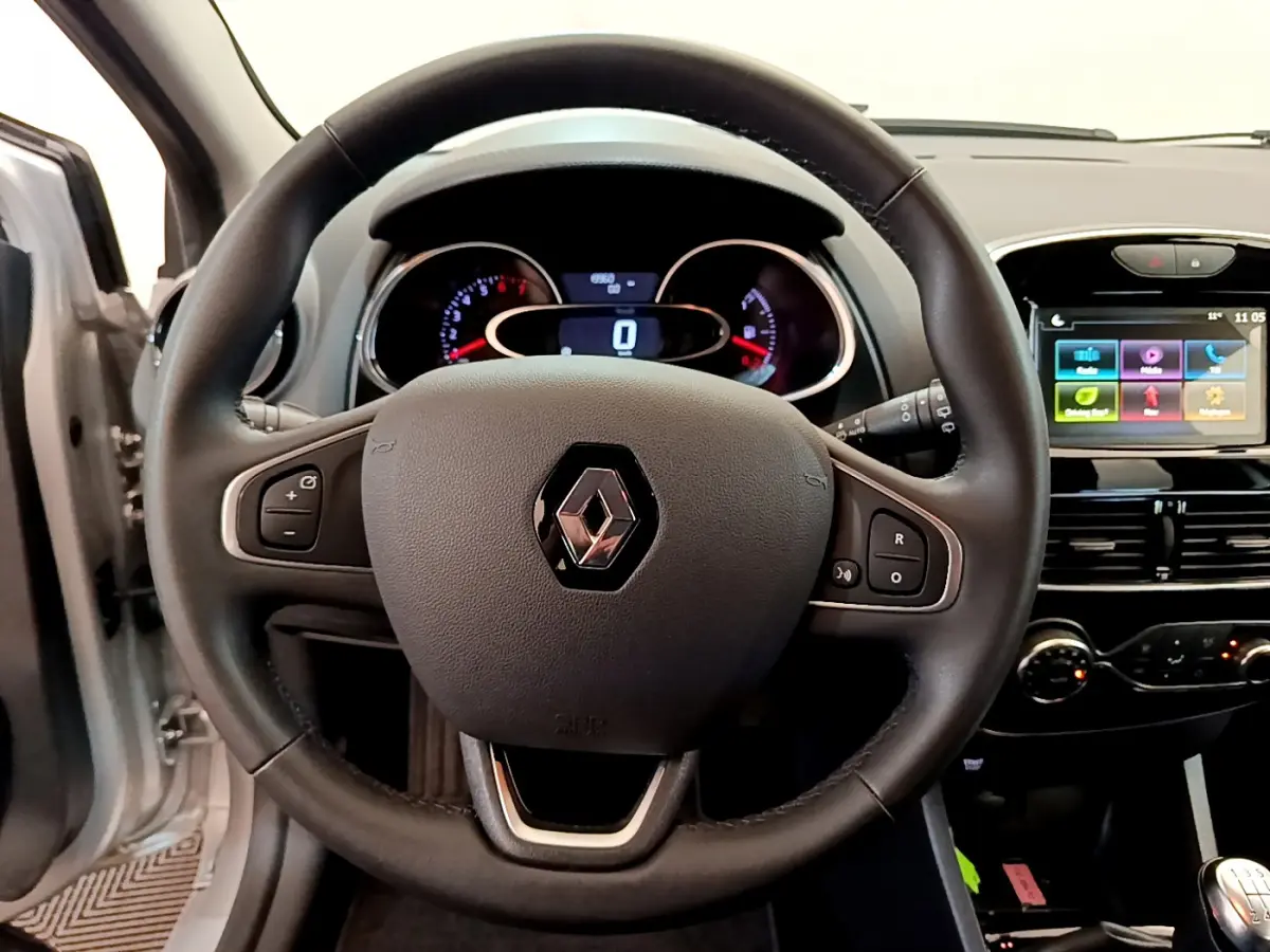 Vue rapprochée du volant cuir noir de la Renault Clio Business TCe 90 2019 avec tableau de bord et écran tactile coloré.