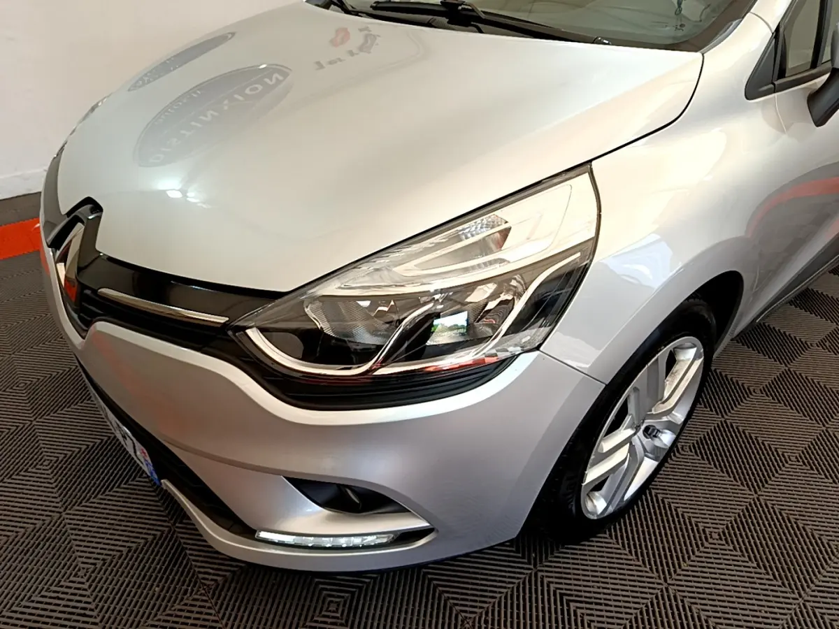 Vue 3/4 avant droit d'une Renault Clio Business TCe 90 gris clair avec phares LED et jantes alliage visibles.