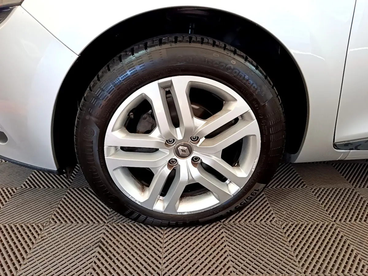 Gros plan sur la roue avant gauche gris clair d'une Renault Clio Business TCe 90 avec jante alliage à 5 branches doubles.