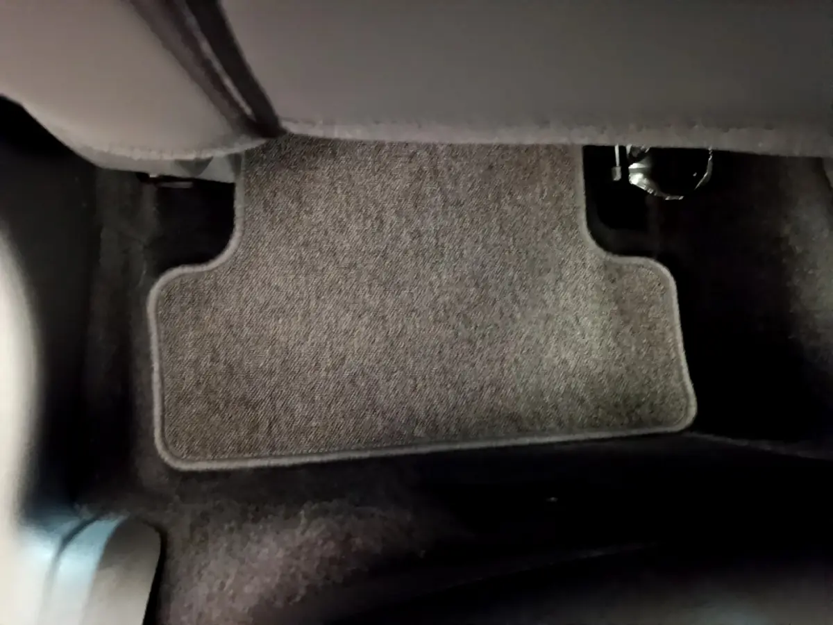 Vue rapprochée du tapis de sol gris clair côté conducteur d'une Renault Clio Business TCe 90 essence 2019.